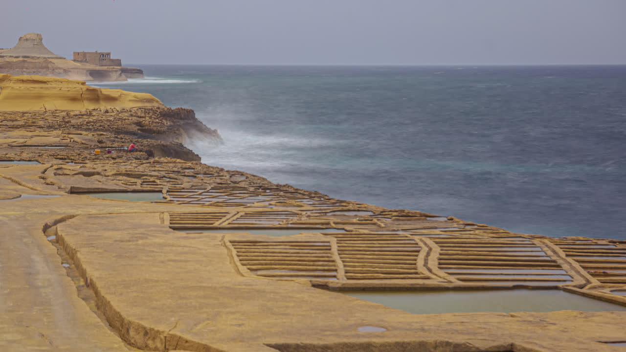 Timelapse footage of waves crashing into the stone embankment on shore