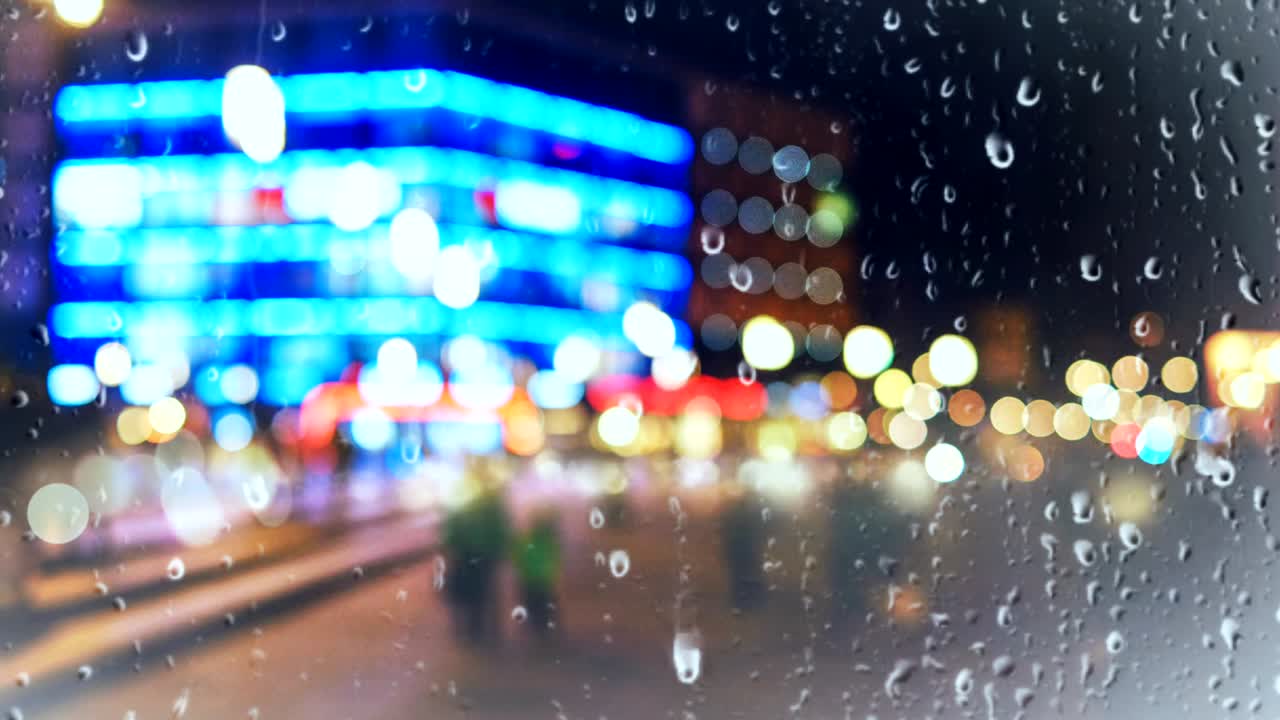 도시 배경의 유리 창에 떨어지는 비방울 아름다운 다채로운 보케 빛 효과.