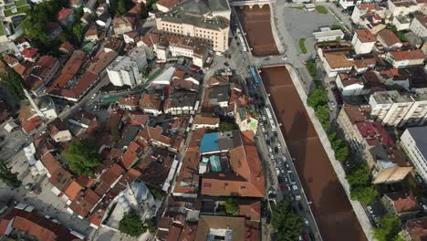 Vista-Aérea-Del-Río-Pasando-Por-La-Ciudad,-Casas-Entre-Las-Montañas,-Vista-Aérea-De-Casas-Techadas