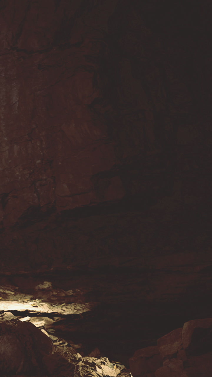 Exploration of a dark cave with soft light illuminating the ground