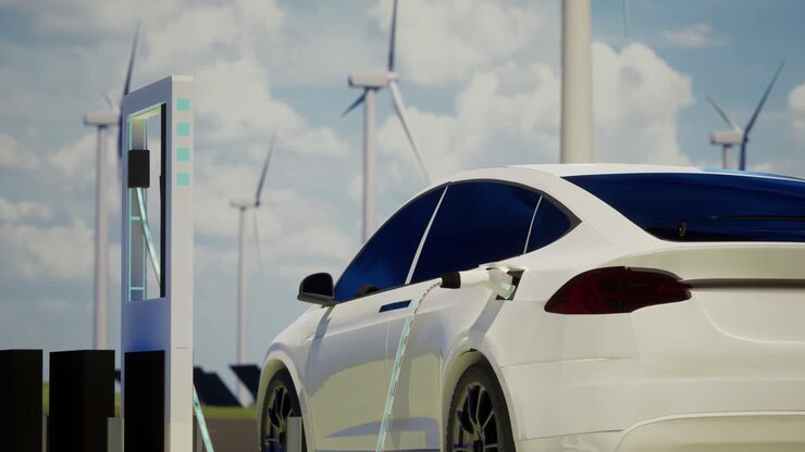 Environmentally Friendly Electric Car Charging On The Background Of Wind Turbines. Clear Blue Sky Background Of Ev Station With Port Plugged In Car, Realistic 3D Rendering, Alternative Energy, Zoom In