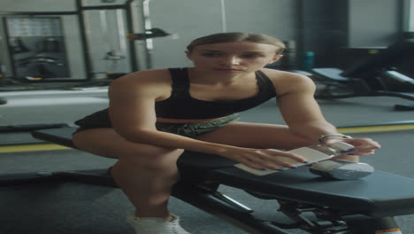 woman drinking water after gym workout