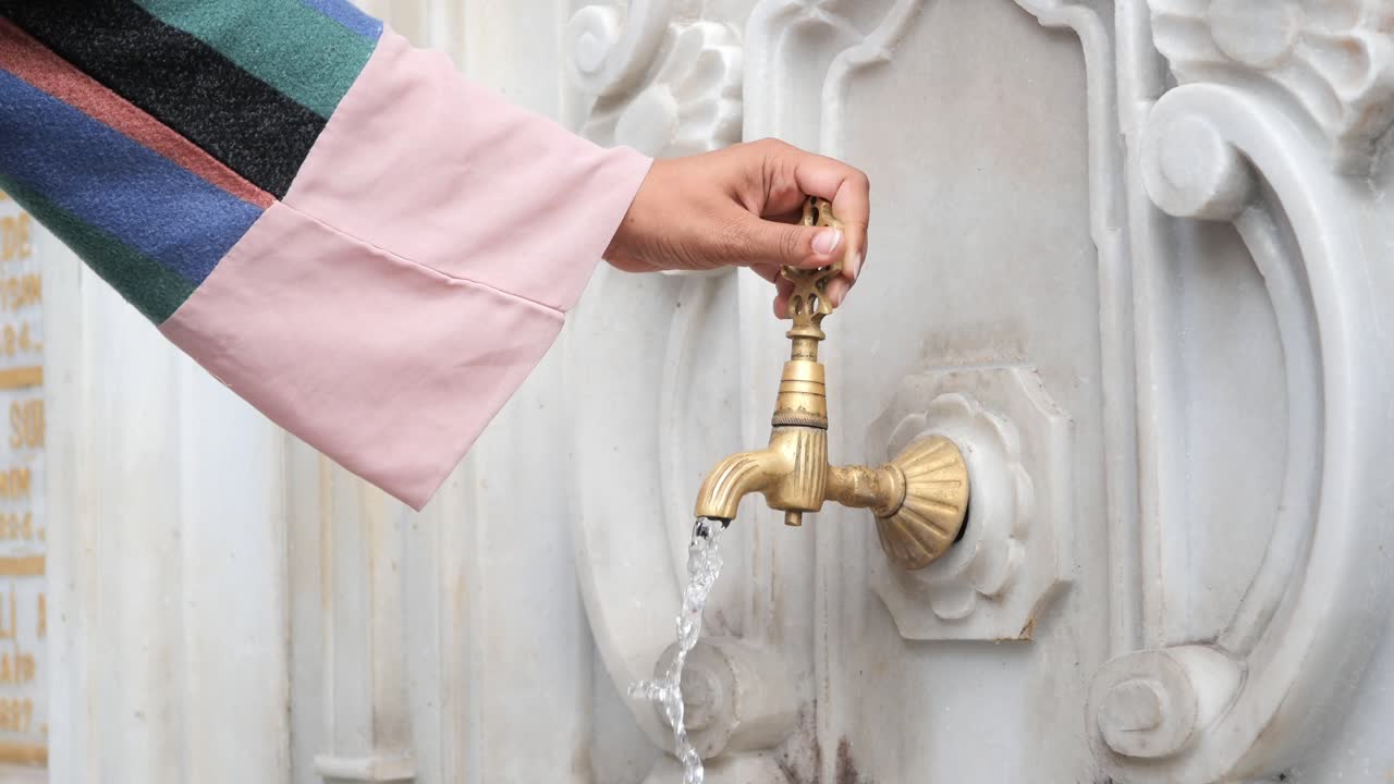 Person using a traditional Turkish water fountain