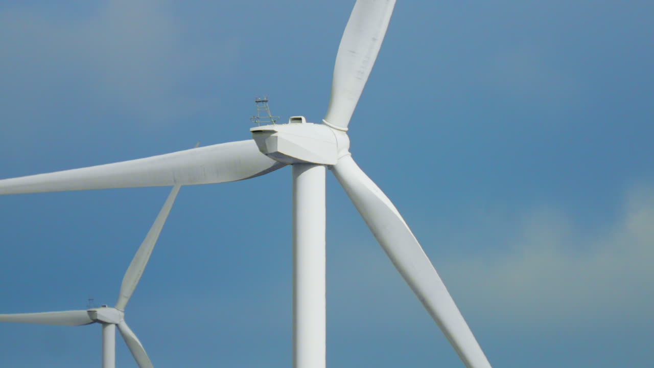 Close Up View Behind Wind Turbine with Blue Sky Background Generating Clean Renewable Electricity