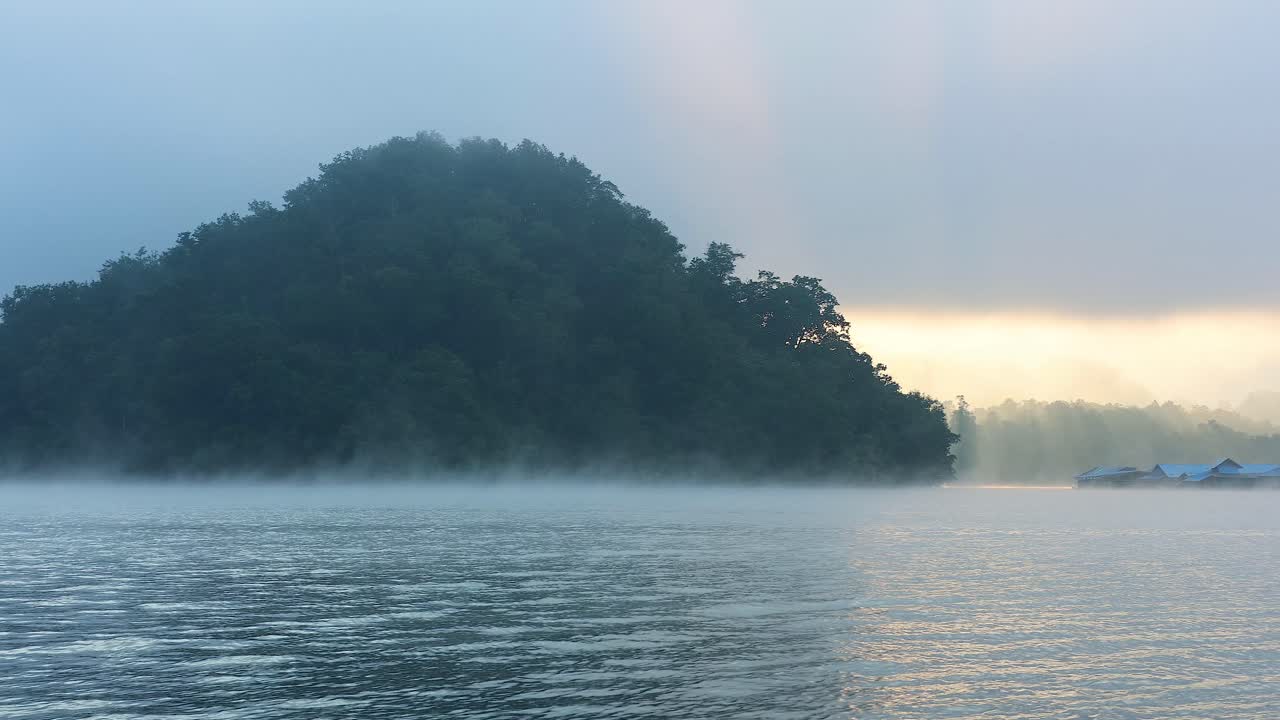 안개 로 인 조용 한 호수 위 에서 해가 뜨는 것