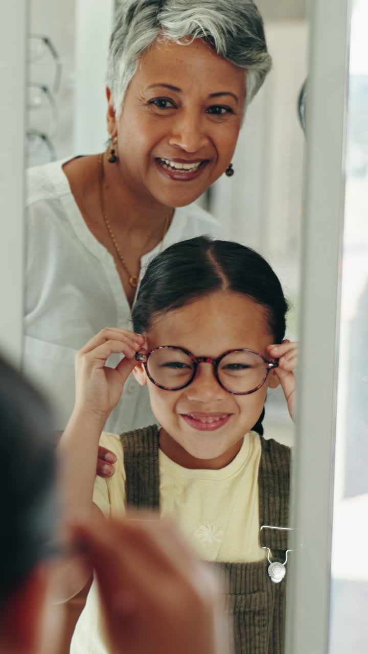 Girl trying on glasses with grandmother