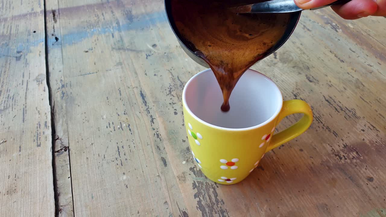 cámara lenta de verter café negro en la taza sobre la vieja mesa de madera retro