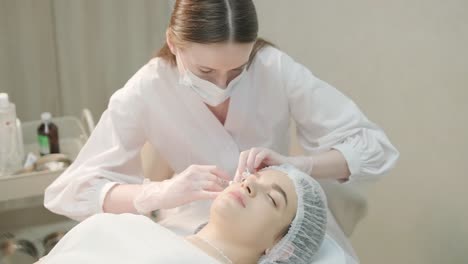 woman undergoing facial treatment at cosmetologist clinic