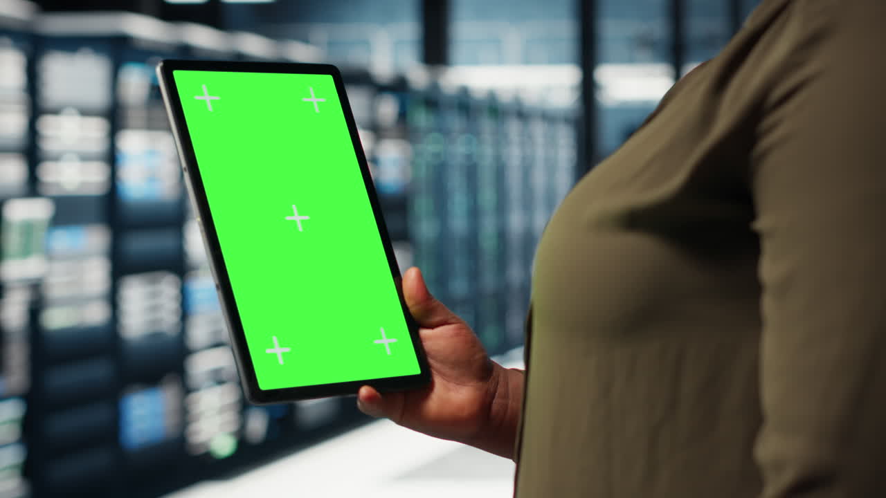 Engineer at work using isolated screen tablet in data center to check hardware