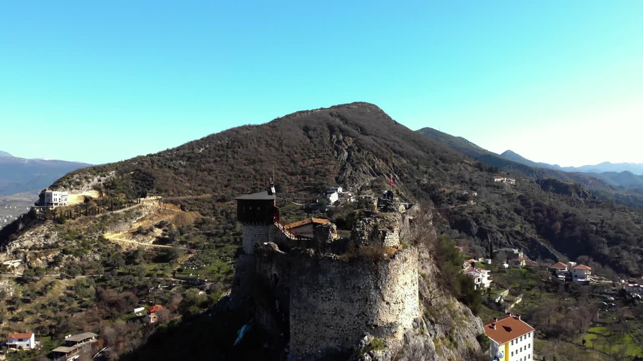 antigua fortaleza con muros de piedra y torre construida sobre una colina rocosa en petrela, albania