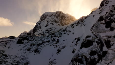 los rayos del sol estallan sobre las escarpadas montañas nevadas del ártico, lofoten antena cinematográfica