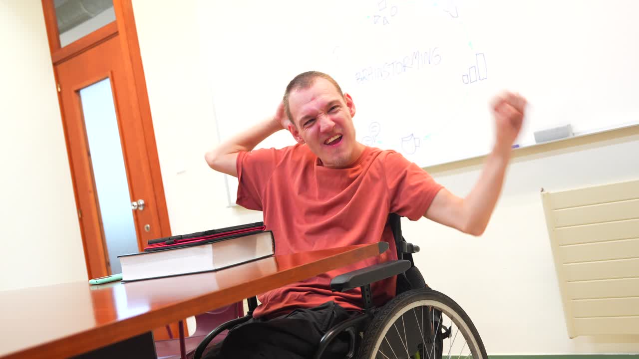 Man in wheelchair celebrating in office