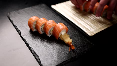 el chef preparando rollos de sushi de salmón con tempura