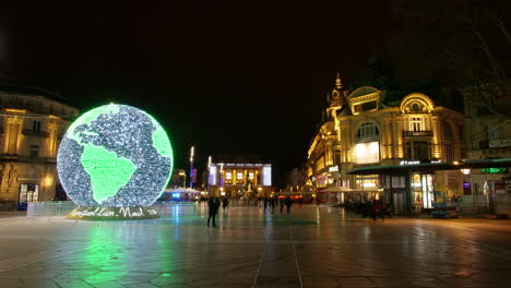 night lapse of montpellier comedy square with world globe illumination. opera