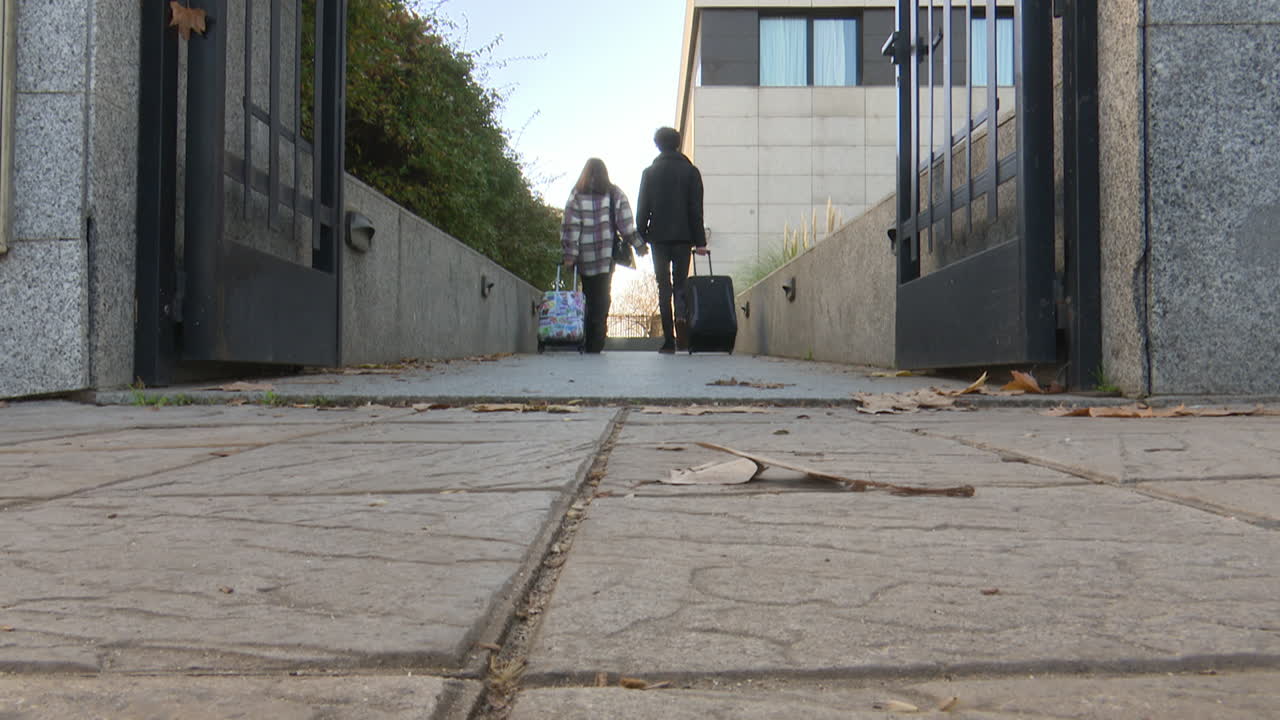 Couple Leaving Hotel with Luggage