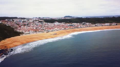 view nazare beach riviera on the coast of atlantic ocean. an iconic place, the mecca of surfing on big waves. aerial view of the old city and promenade