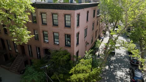 People-cycling-in-front-of-a-brownstone-house,-in-Brooklyn-Heights,-NY,-USA---Aerial-view