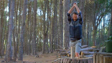 male logger chopping wood with an axe in the forest 4k