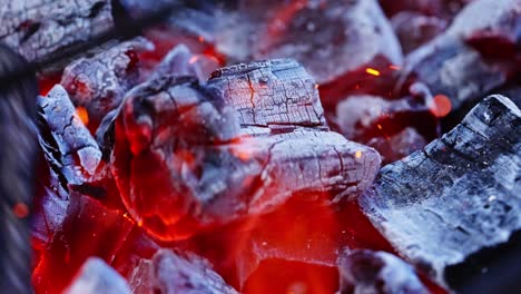 glowing red coals burn intensely with heat and flames rising from blackened wood, backdrop background