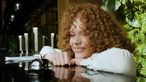 Close-up-view-of-funny-redheaded-receptionist-behind-the-counter