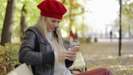 Mujer-En-Boina-Con-Smartphone-En-El-Parque