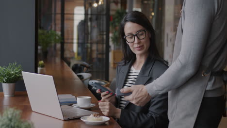 businesswoman paying at a cafe