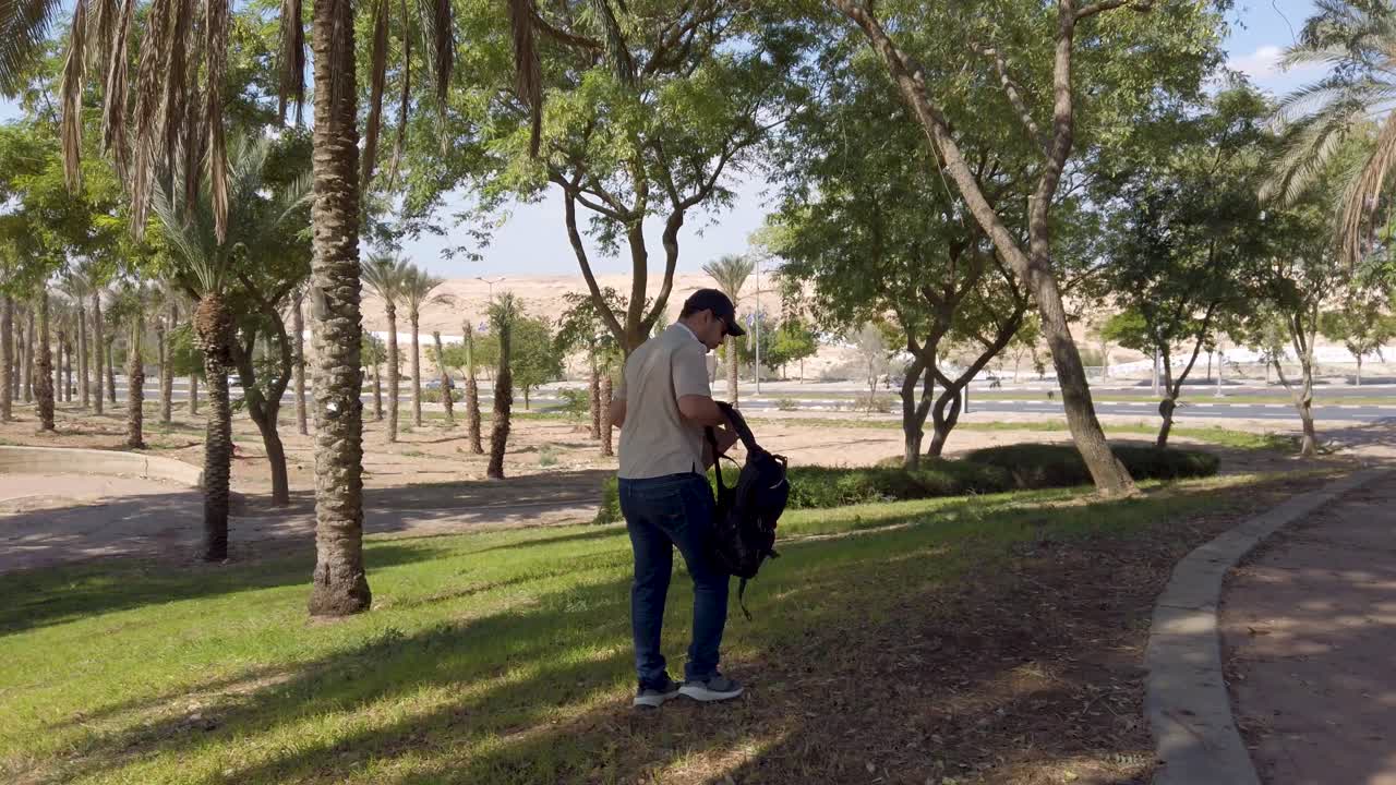 Young man sitting on the grass in a park.