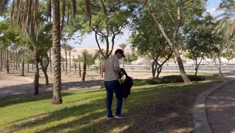 young man sitting on the grass in a park.