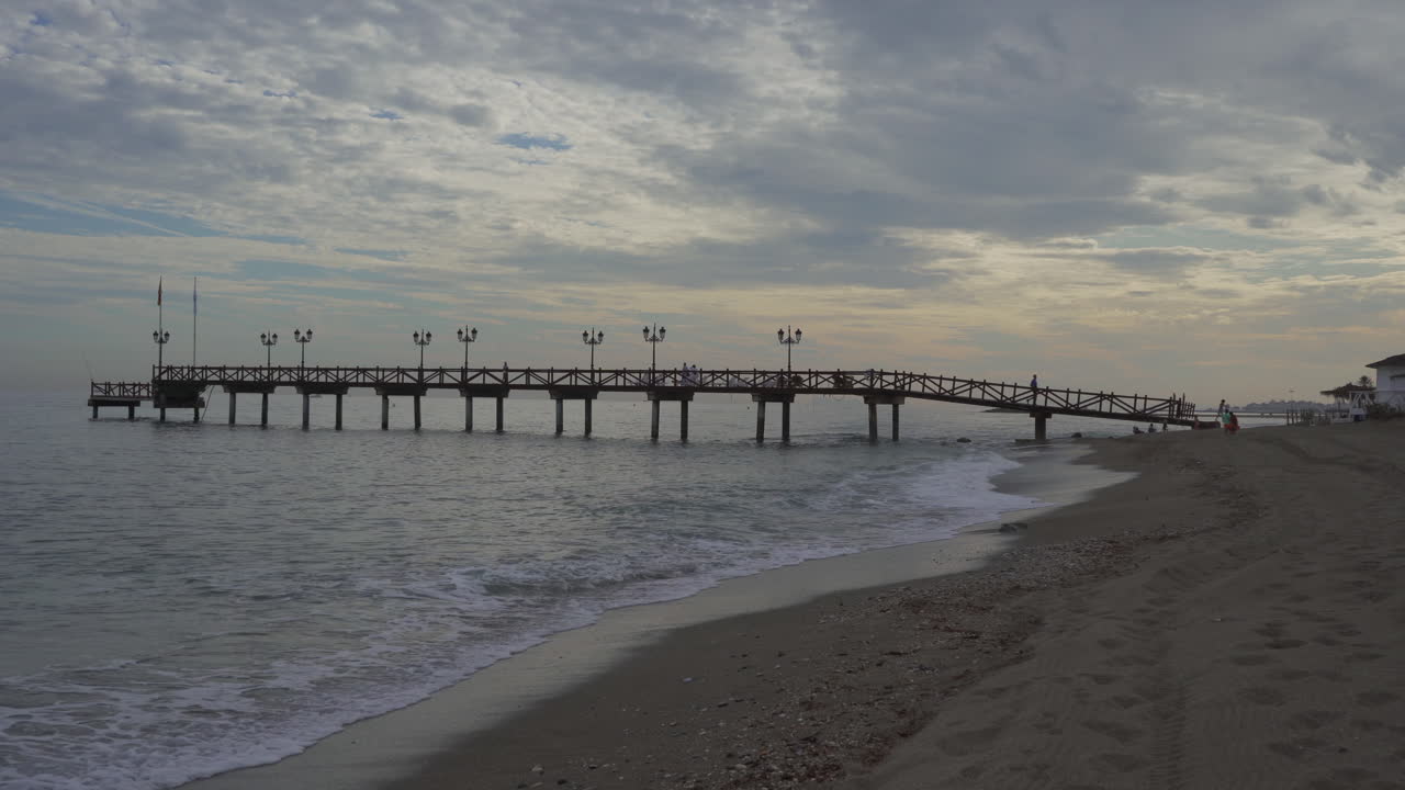 Molo di legno di Marbella in una giornata nuvolosa, vista drammatica della costa spagnola