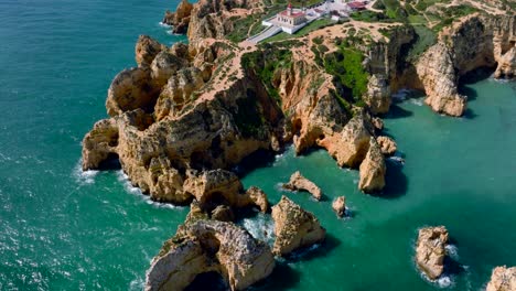 Toma-Panorámica-De-Drones-Desde-La-Costa-Del-Algarve,-Revelando-Un-Faro-En-La-Costa