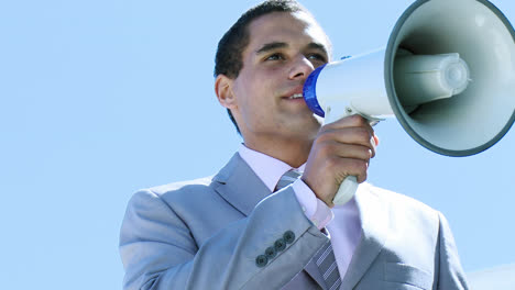 businessman shouting through a megaphone outdoors