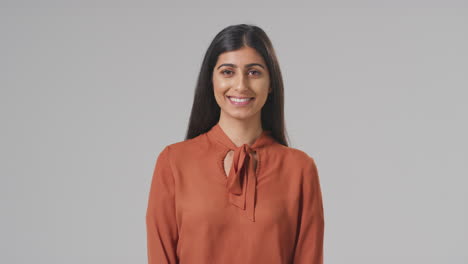 Studio-Portrait-Of-Smiling-Young-Businesswoman-Against-Plain-Background