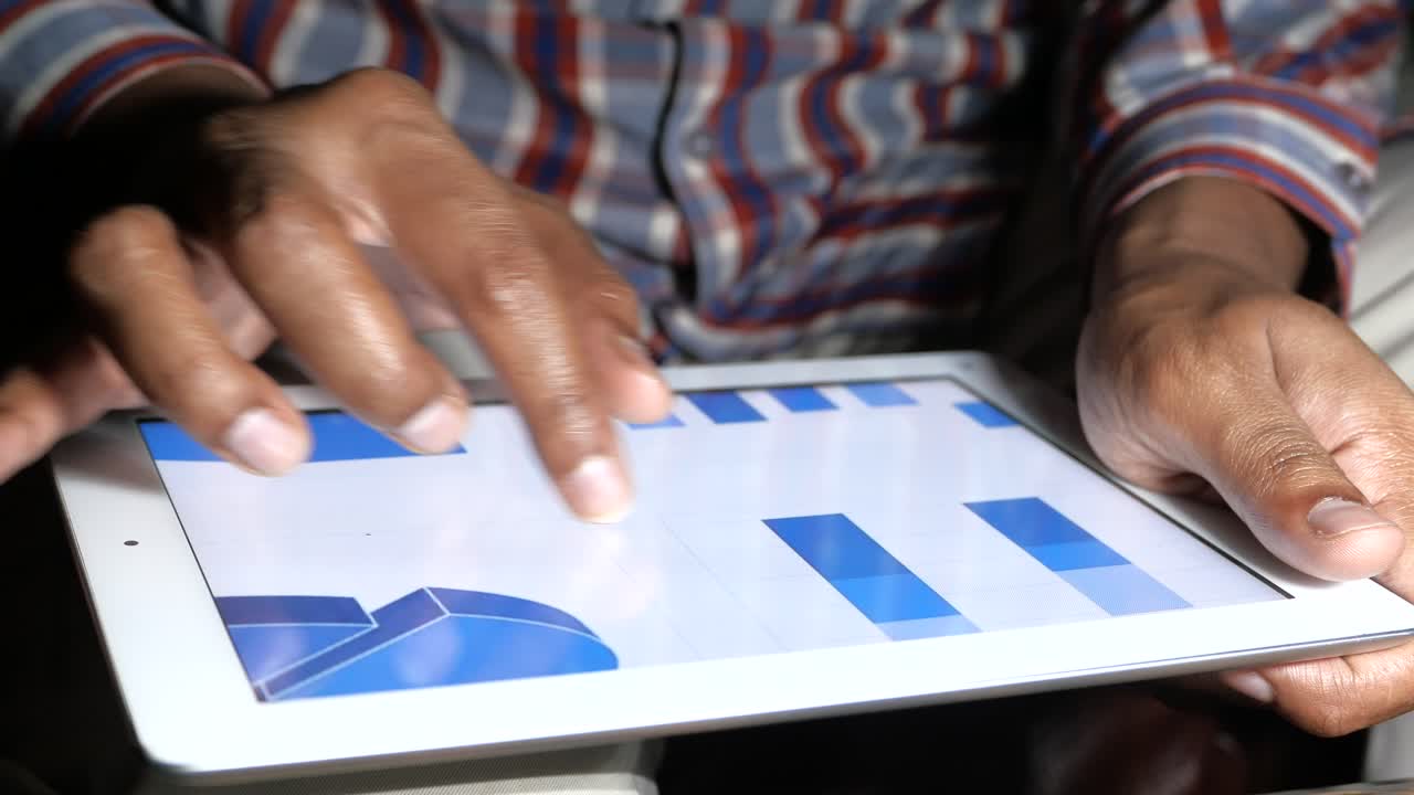 persona que utiliza una tableta para ver gráficos y gráficos