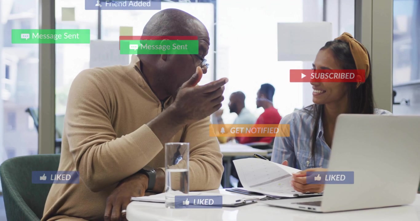 Colleagues Collaborating on a Project in a Modern Office with Social Media Graphics