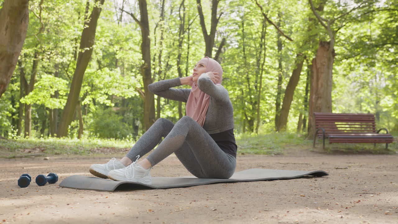 mujer haciendo abdominales en un parque