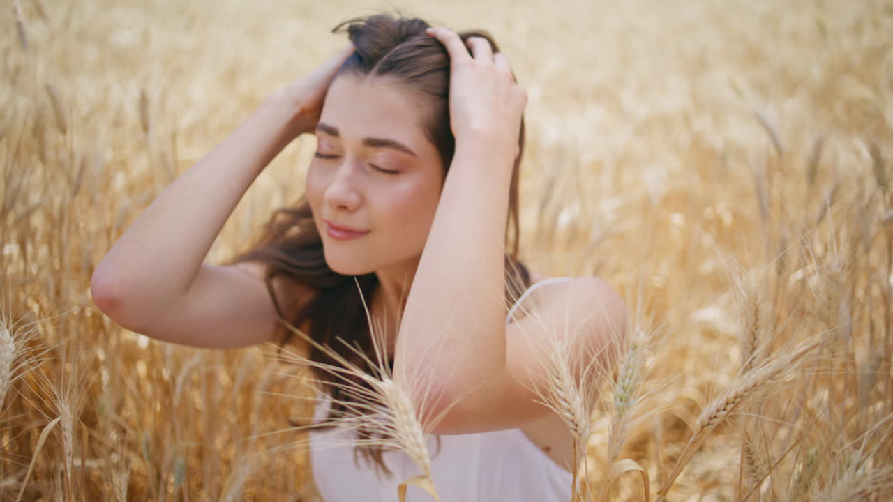 바람이 불고 있는 날씨를 즐기고 있는 여름 모델. 만족한 여자가 휴식을 취하고 있다.