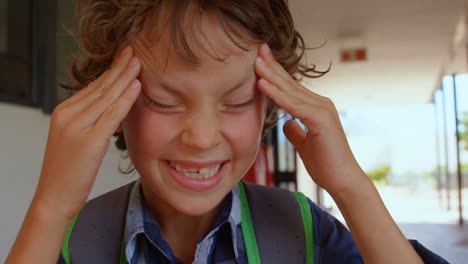 Vista-Frontal-De-Un-Colegial-Caucásico-Irritado-Parado-En-El-Pasillo-De-La-Escuela-4k