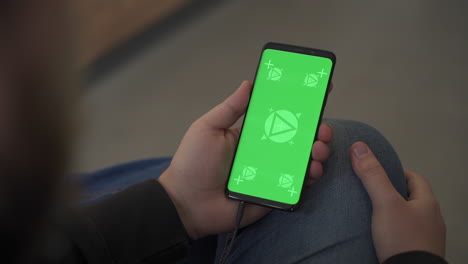Holding-smartphone-with-horizontal-green-screen-chroma,-reading,-touching.-Mockup-close-up.