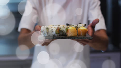 Animation-of-white-spot-lights-over-male-chef-serving-sushi