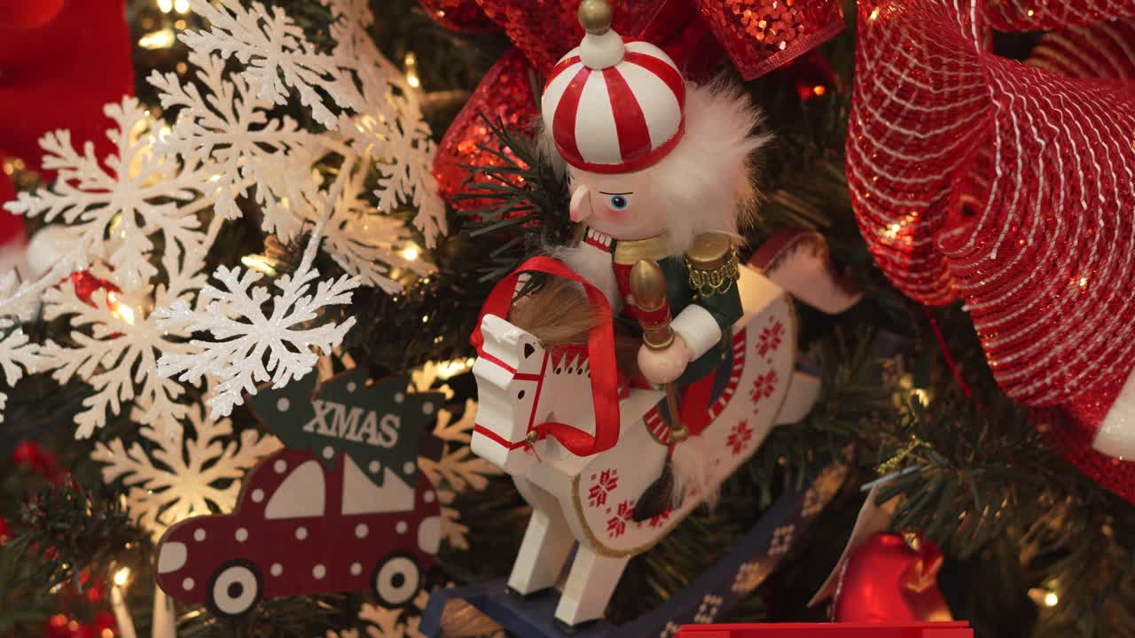 Close-up of Christmas decoration with nutcracker riding horse and car on illuminated tree. 4k.
