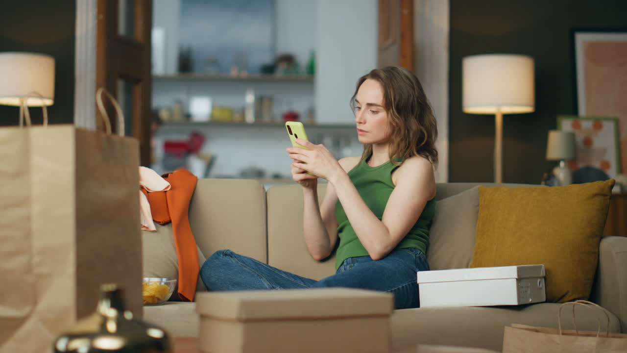 Focused girl typing mobile phone sitting home. Shopping addicted woman ordering