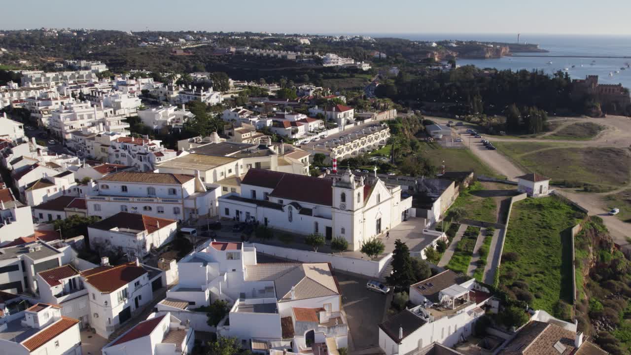 vista aérea de la iglesia blanca de ferragudo en la cima de la colina con vistas al río arade