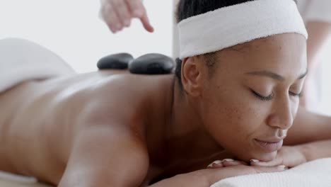mujer recibiendo un masaje con piedras calientes