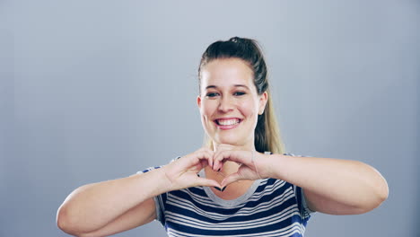 mujer haciendo forma de corazón con las manos