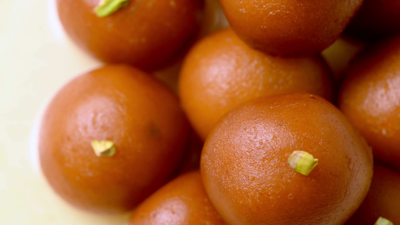 Gulab jamun rotante con granella di pistacchio (dolce indiano) | Dessert | Primo piano