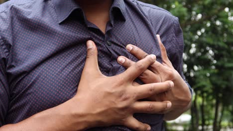 young man suffering pain in heart and holding chest with hand