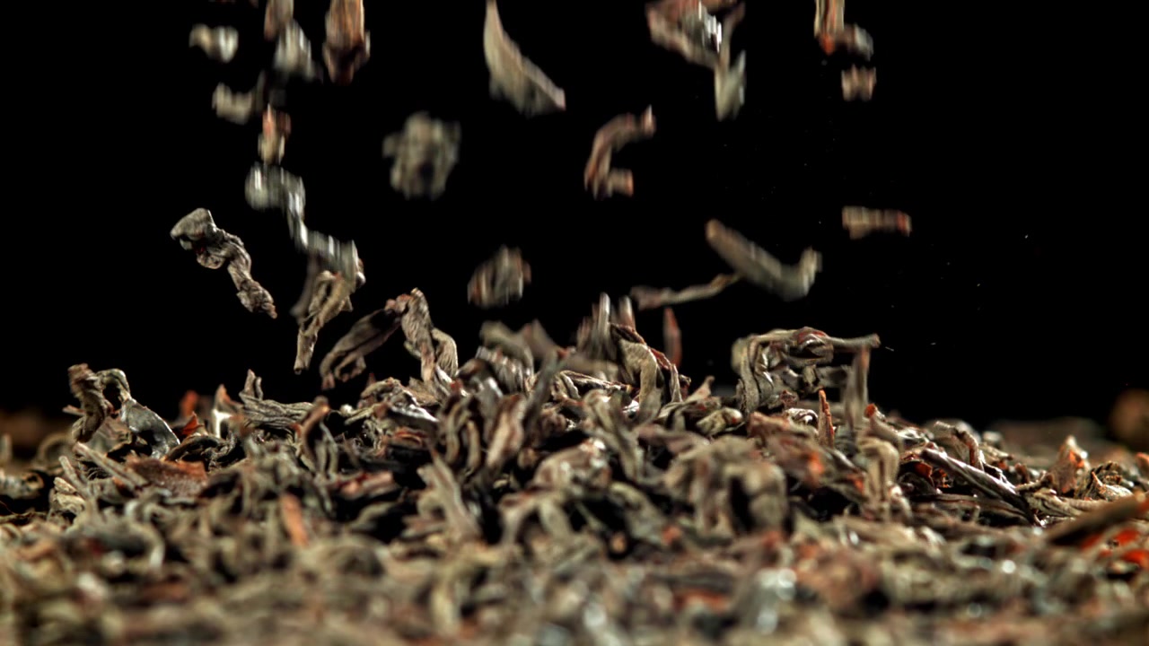 Dry Black Tea Leaves Falling and Scattering in Slow Motion