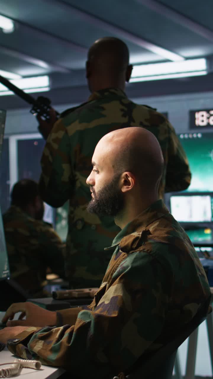 Video verticale: Ufficiale utilizza attrezzature di monitoraggio nella base operativa per il nemico