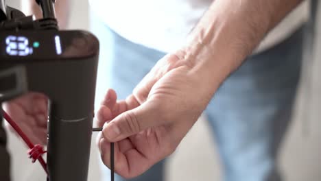 primer plano de un chico que trabaja en un scooter eléctrico en la tienda
