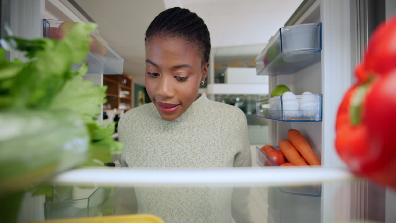 Woman looking at food inside fridge